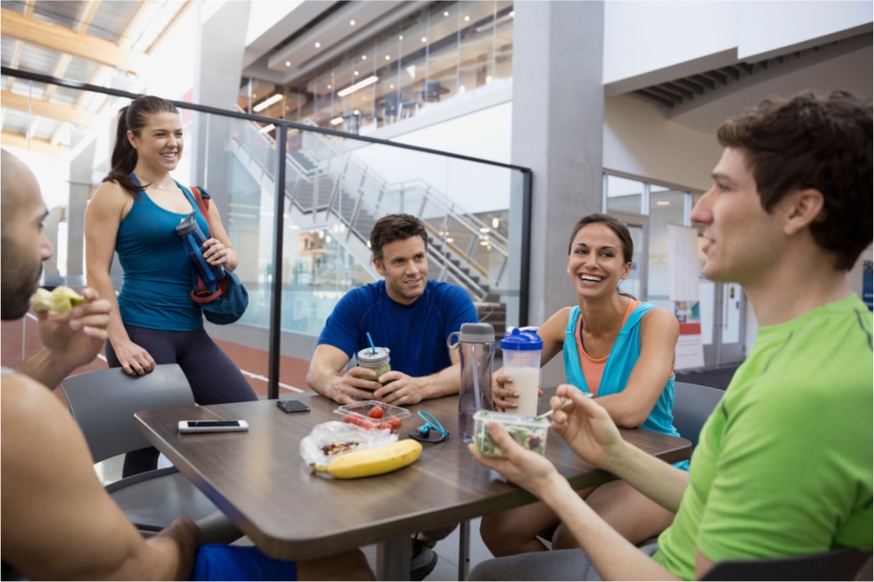 Friends in workout gear sitting around a small table