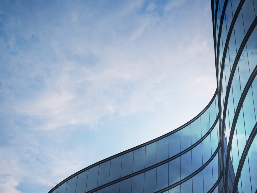 The top of a wavy building against a blue sky