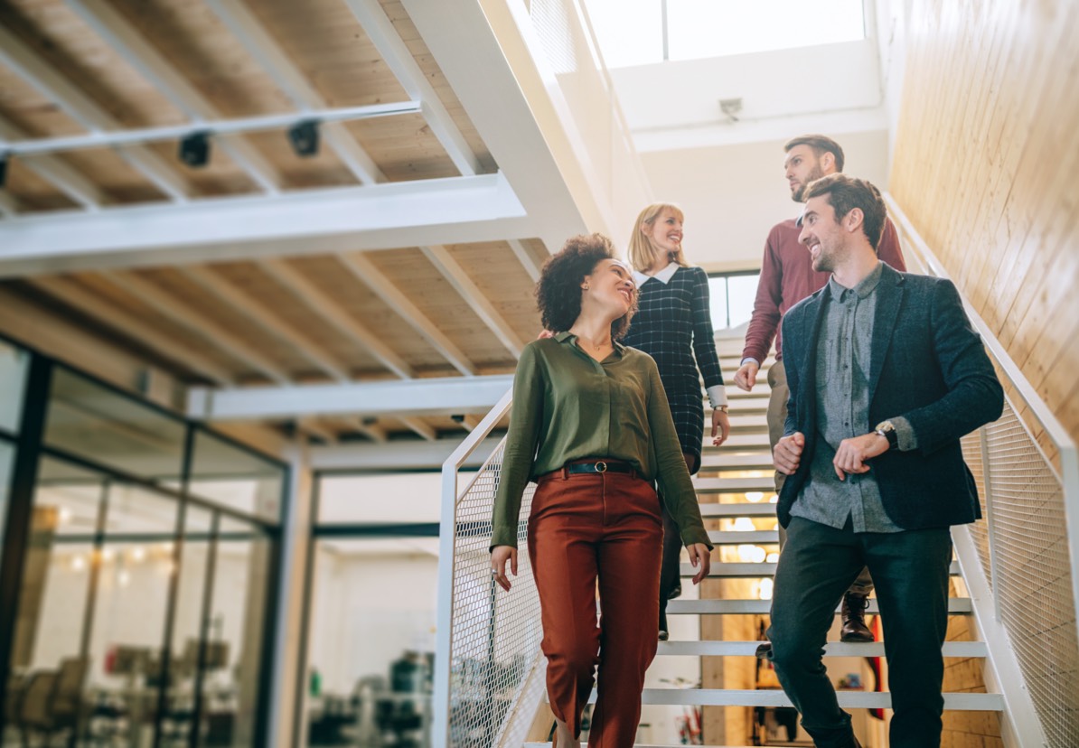 Two men and two women walking down an office staircase at Panorama