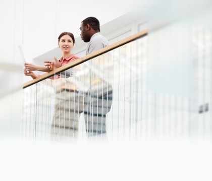 Man and woman standing near a balcony railing, talking about Panorama insurance